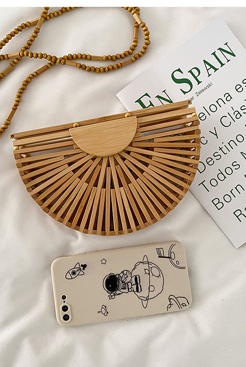 Light brown handbag, made of bamboo. It has a magnet that closes the bag securely. This bag is perfect for your vacation, and can go with any beach outfit. You can use it with or without the strap.