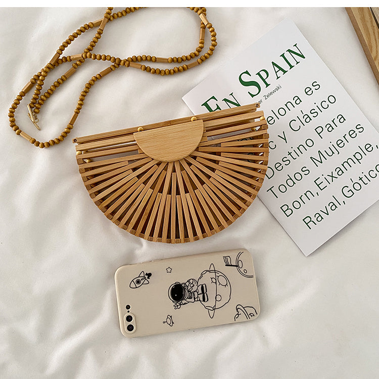 Light brown handbag, made of bamboo. It has a magnet that closes the bag securely. This bag is perfect for your vacation, and can go with any beach outfit. You can use it with or without the strap.