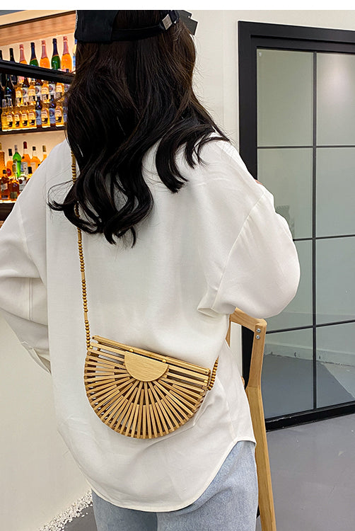 Light brown handbag, made of bamboo. It has a magnet that closes the bag securely. This bag is perfect for your vacation, and can go with any beach outfit. You can use it with or without the strap.