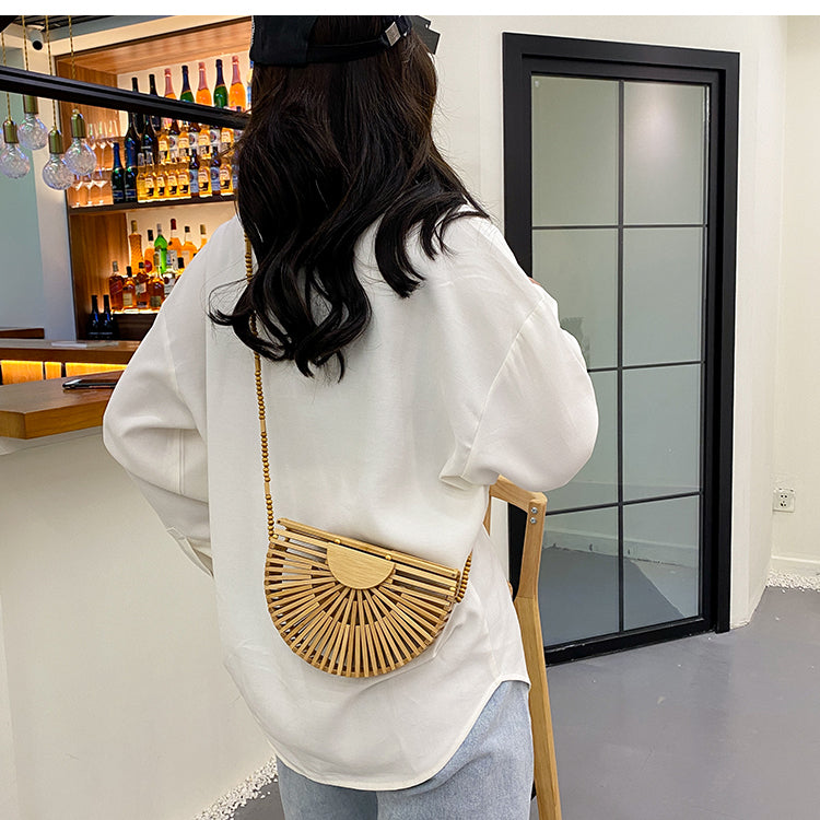 Light brown handbag, made of bamboo. It has a magnet that closes the bag securely. This bag is perfect for your vacation, and can go with any beach outfit. You can use it with or without the strap.