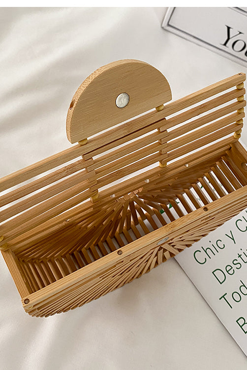 Light brown handbag, made of bamboo. It has a magnet that closes the bag securely. This bag is perfect for your vacation, and can go with any beach outfit. You can use it with or without the strap.