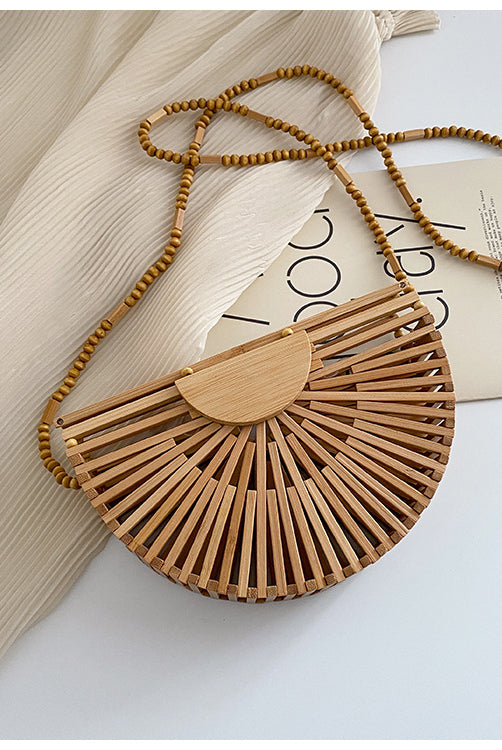 Light brown handbag, made of bamboo. It has a magnet that closes the bag securely. This bag is perfect for your vacation, and can go with any beach outfit. You can use it with or without the strap.