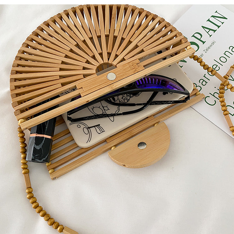 Light brown handbag, made of bamboo. It has a magnet that closes the bag securely. This bag is perfect for your vacation, and can go with any beach outfit. You can use it with or without the strap.